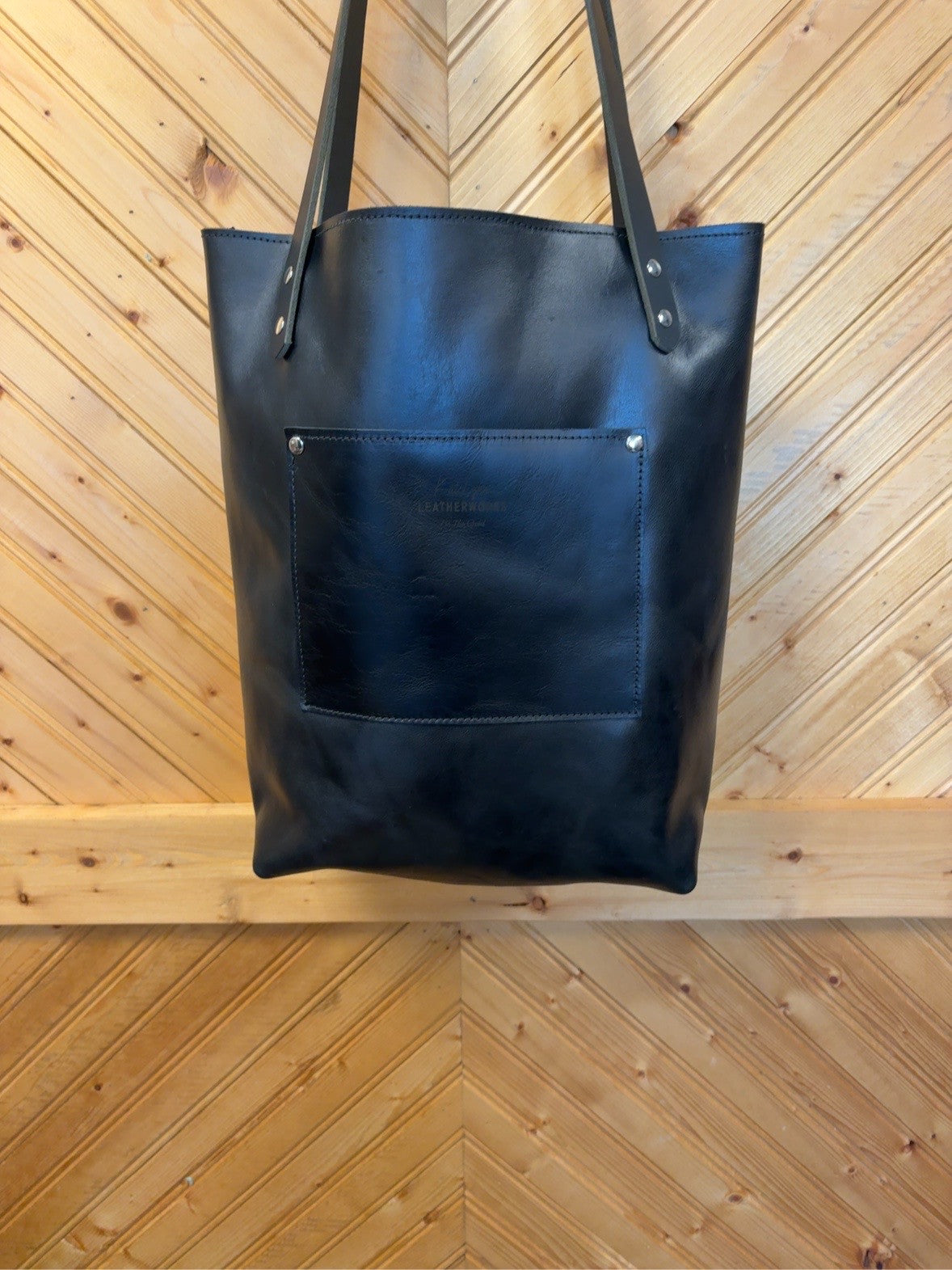 Black back of the Unicorn Foil Bristow Bookbag showing an exterior pocket, KateLynn Leatherworks stamp, black shoulder straps and silver-tone rivets.