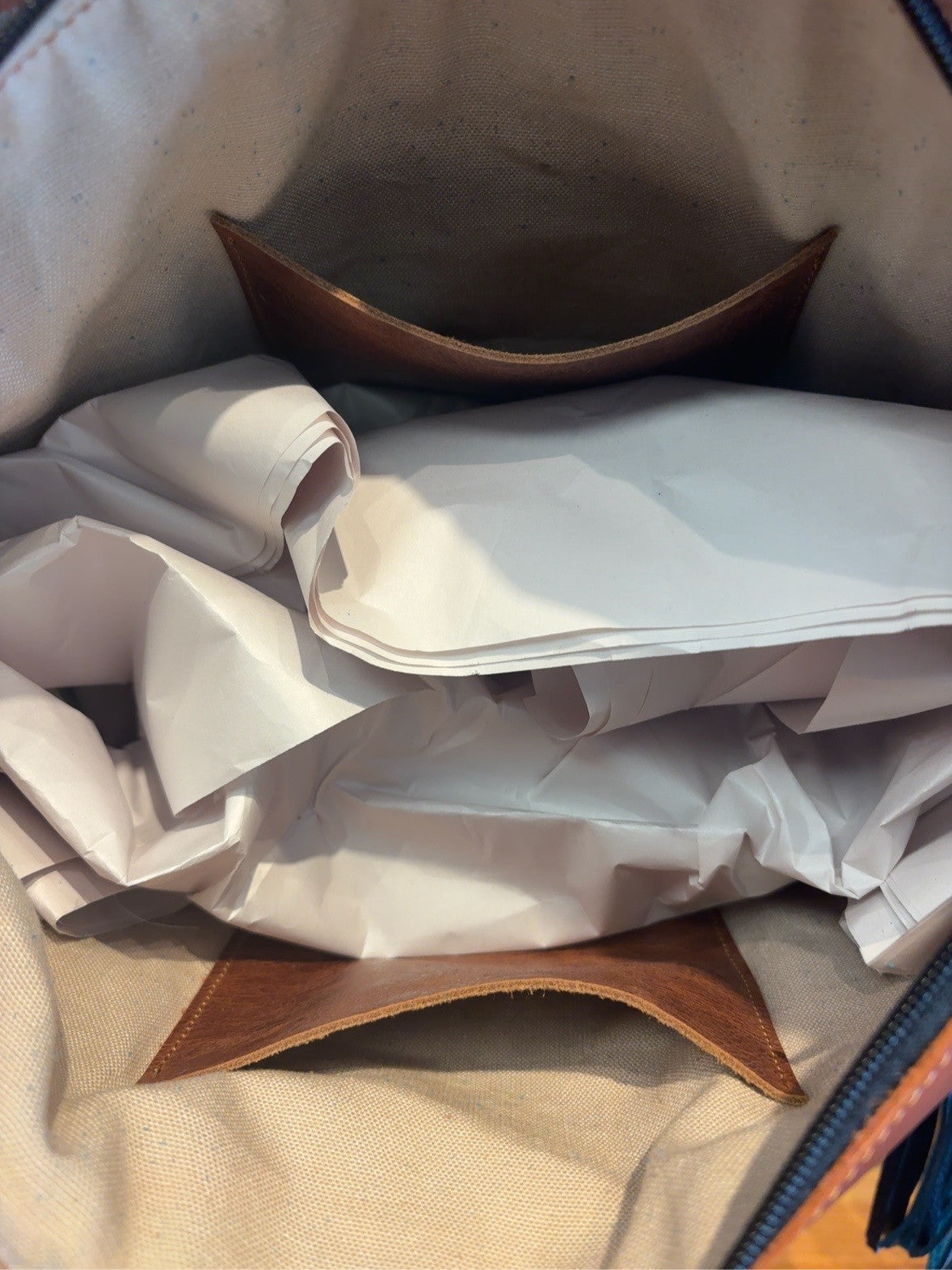 Interior of the Tucson tote showing a light-colored interior and two brown slip pockets.