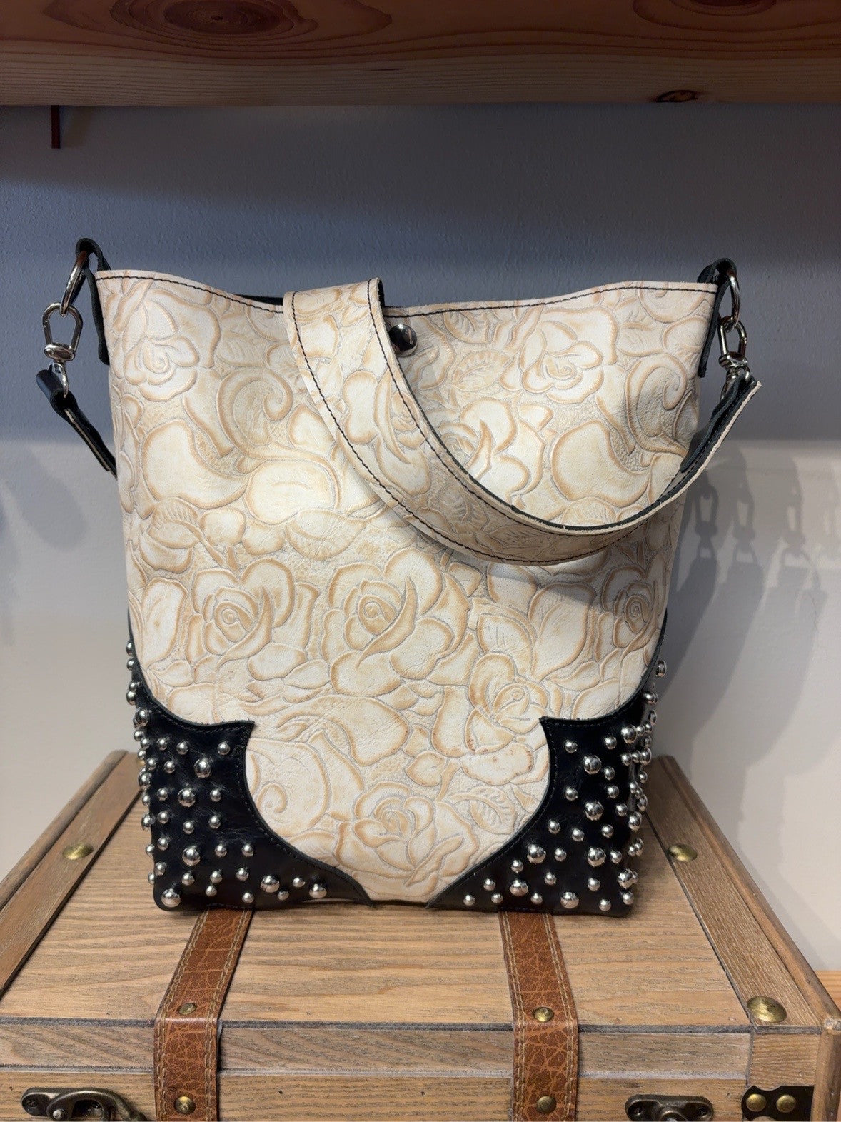 Yukon shoulder bag with ivory rose-embossed leather, black corners and silver studs