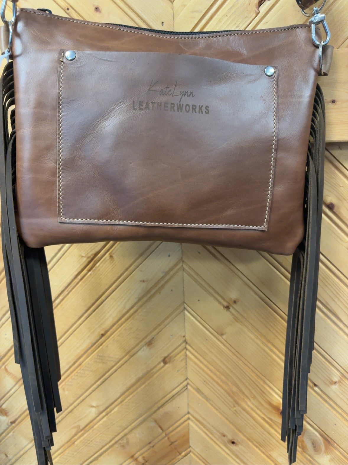 Brown back of the Austin bag with a KateLynn Leatherworks rear pocket and long dark-brown fringe