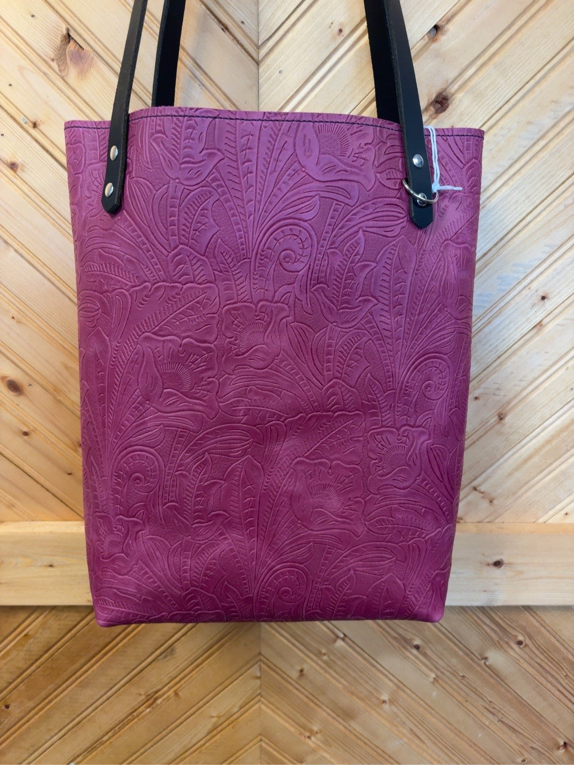 Front of the Rouge Floral & Pink Bristow Bookbag with rouge embossed flowers, black shoulder straps and silver-tone rivets.