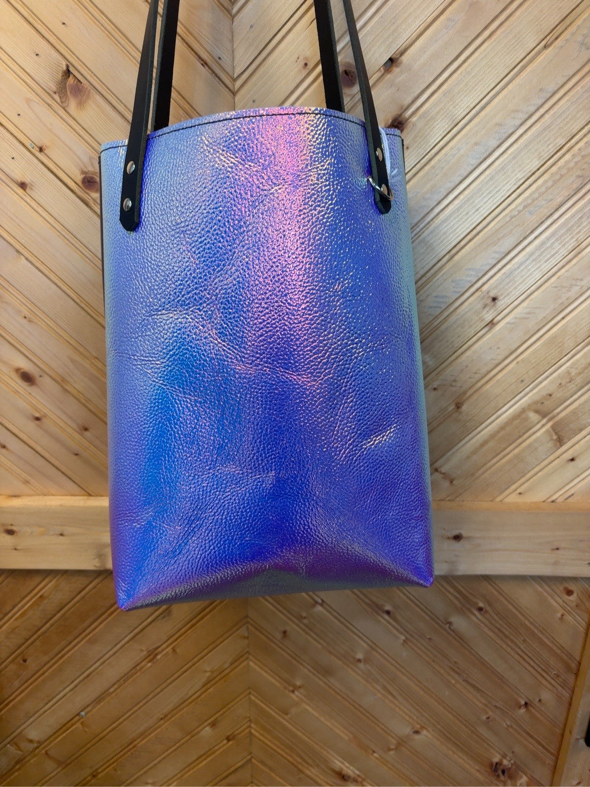 Front of the Unicorn Foil & Plum Bristow Bookbag with an iridescent blue-purple finish, pink-gold highlights, black shoulder straps and silver-tone rivets.