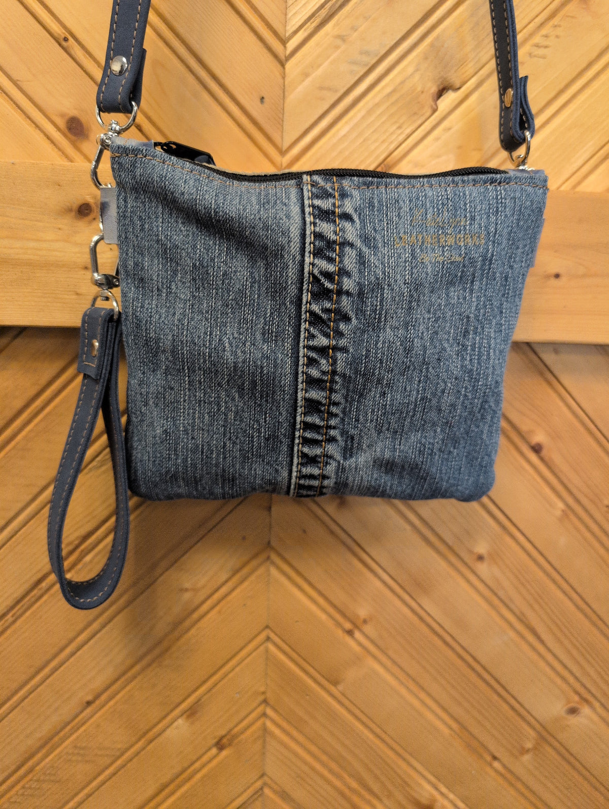 Denim back of Purse Sidekick with contrasting stitched center seam and zipper-top closure