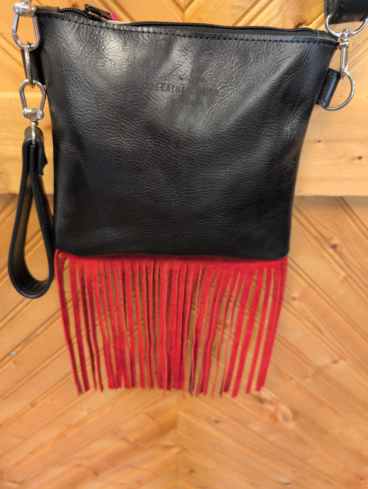 Black back of Purse Sidekick with bottom fringe, wristlet strap and zipper closure