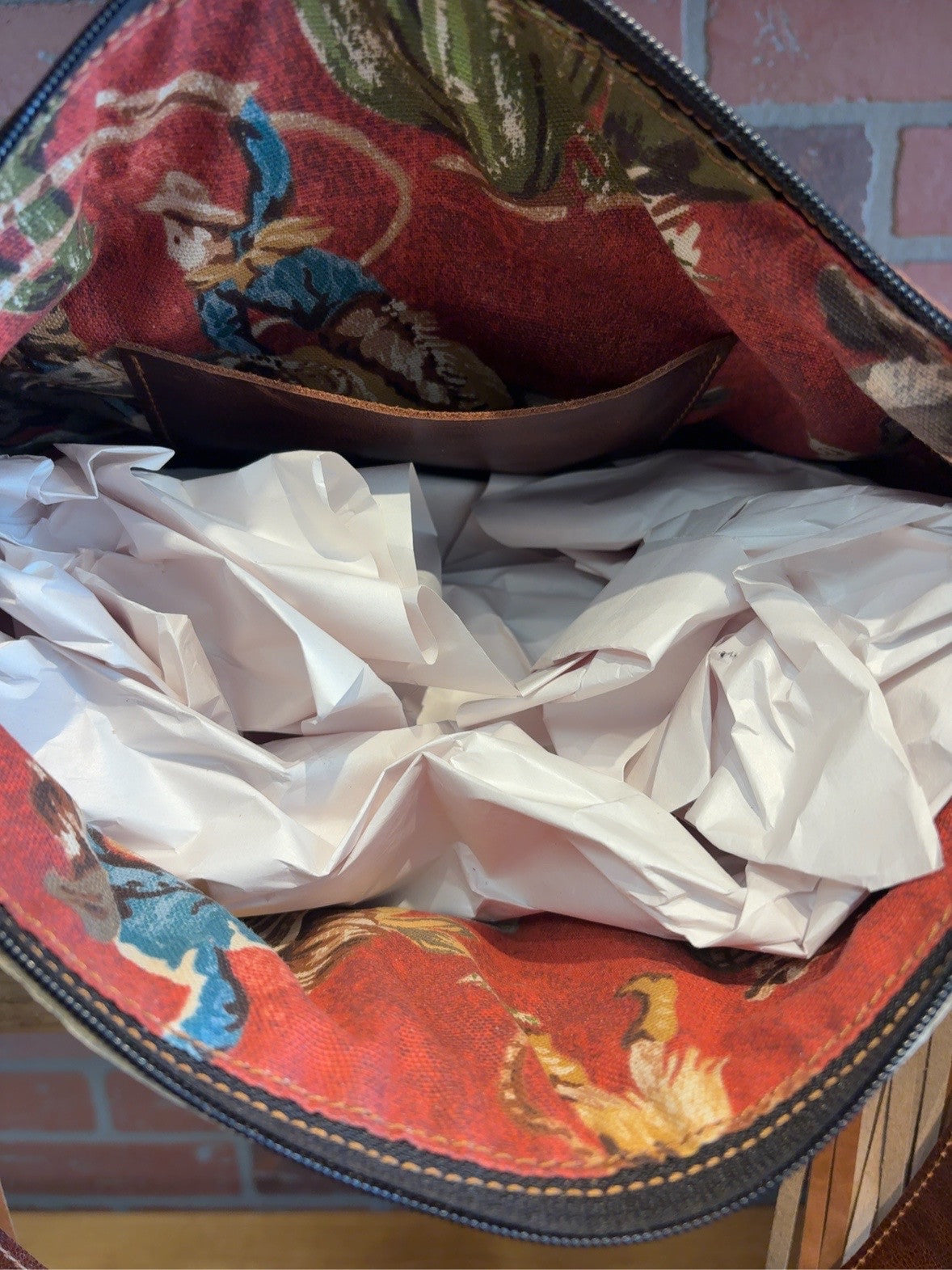 KC bag interior with red Western-print lining and one brown interior pocket.