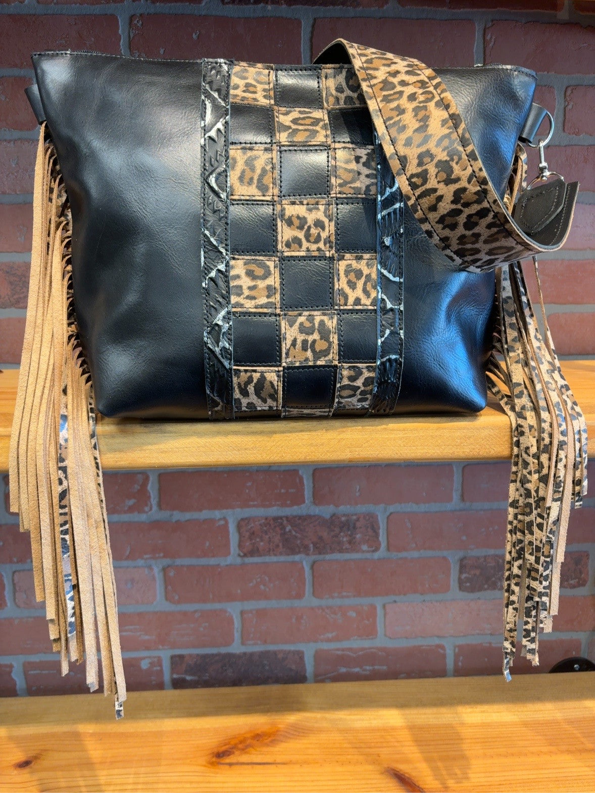 Black KC bag with a Leopard Checkered center, silver-and-black Aztec stripes, leopard-patterned strap and long side fringe.