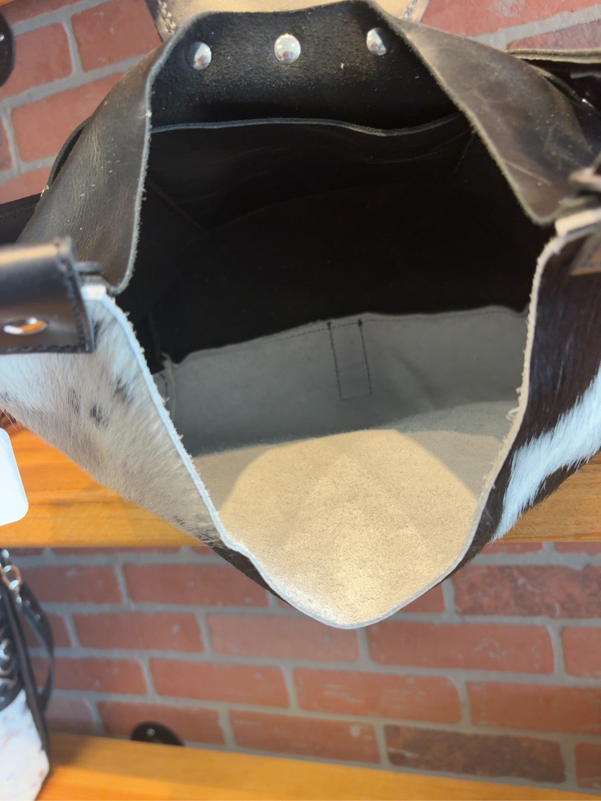 Open Lex shoulder bag showing the interior pocket, stitched seams and underside of the studded flap.