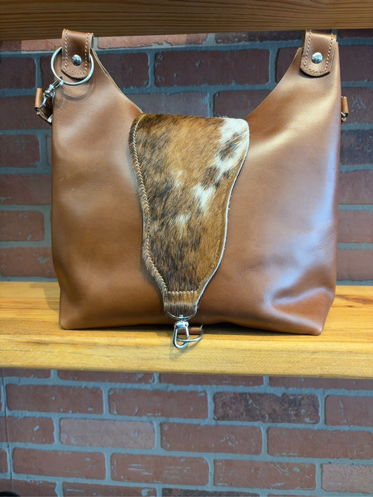 Front of brown Lex shoulder bag with a brindle cowhide flap and silver-tone clip closure.
