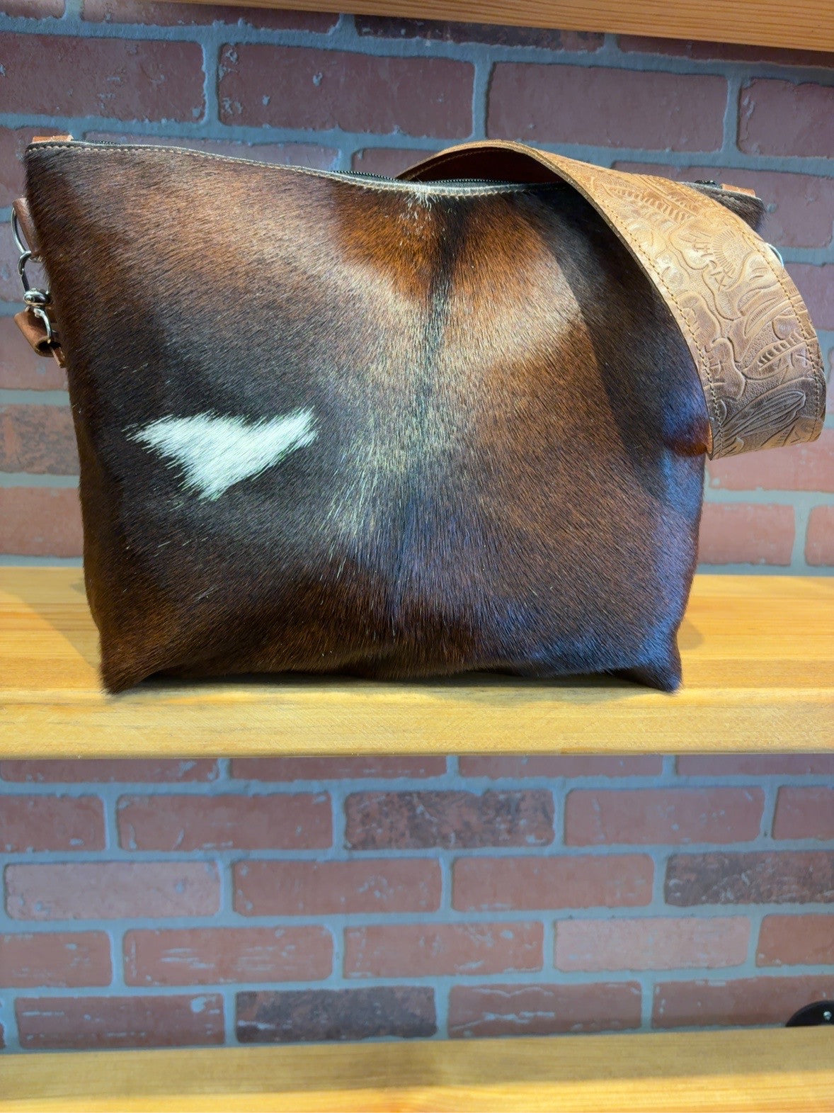 KC bag with a brown and black hair-on front, white patch and Honey Floral embossed shoulder strap.