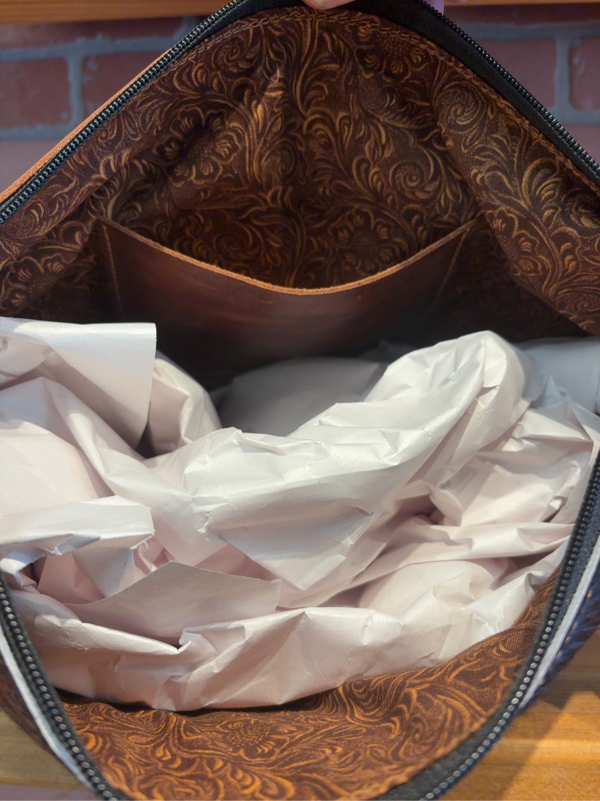 KC bag interior showing a brown scroll pattern, one interior pocket and zipper opening.