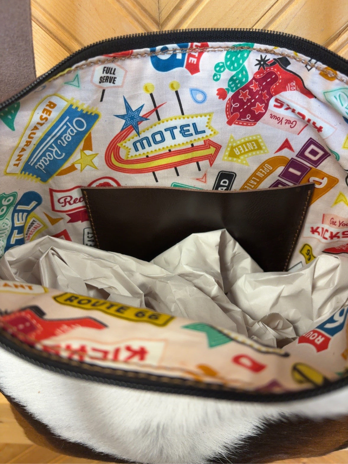 Tucson Mini interior with colorful Route 66 roadside-sign lining and a brown slip pocket