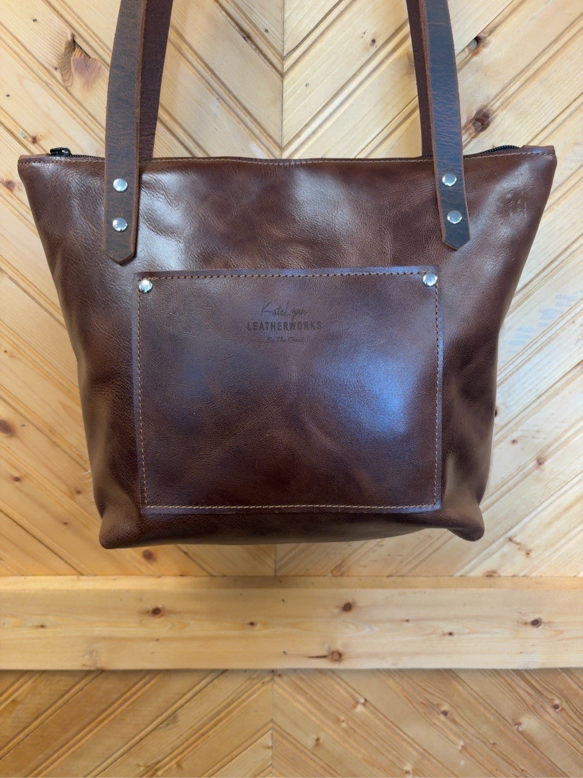 Brown leather back of Tucson Mini showing the exterior slip pocket and shoulder straps