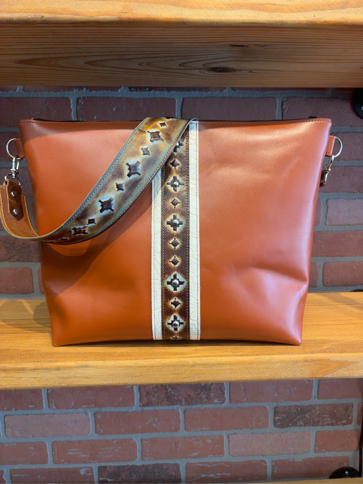Front of the Tucson tote with an embossed Navajo-pattern center stripe and matching wide strap, framed by ivory rose-pattern trim.